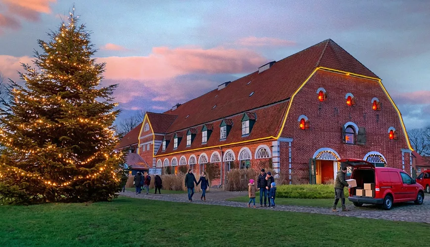 Gut Pronstorf mit Weihnachtsbaum und Lieferwagen in der Abenddämmerung